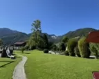 Terrassenausblick über grünen Rasen auf Berge unter blauem Himmel