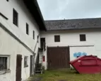 Aussenansicht des Hofs mit Holztor als Zugang zum Scheunentrakt