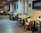 Sitzgelegenheiten mit Tischen und Stühlen auf Dielenboden